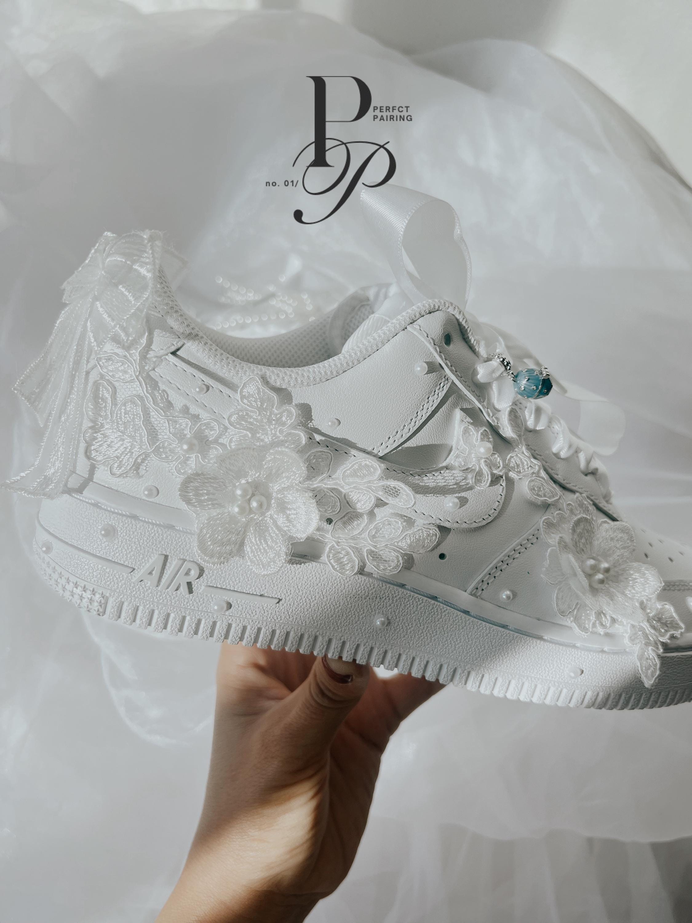 Side view of white Nike Air Force wedding sneakers with delicate hand embroidery and pearl bridal details.