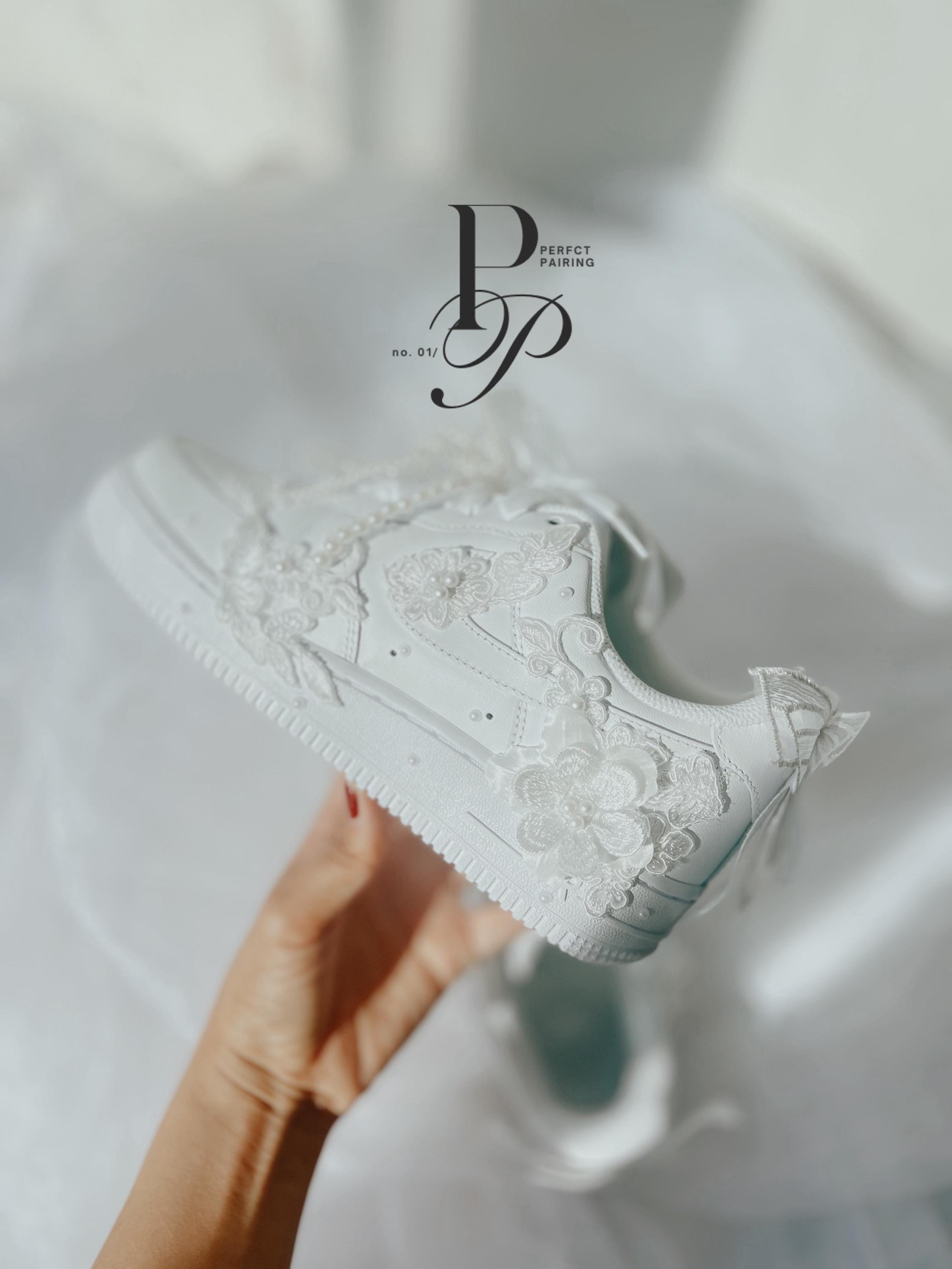Close-up of hand embroidered floral designs and pearls on custom Nike Air Force bridal sneakers.