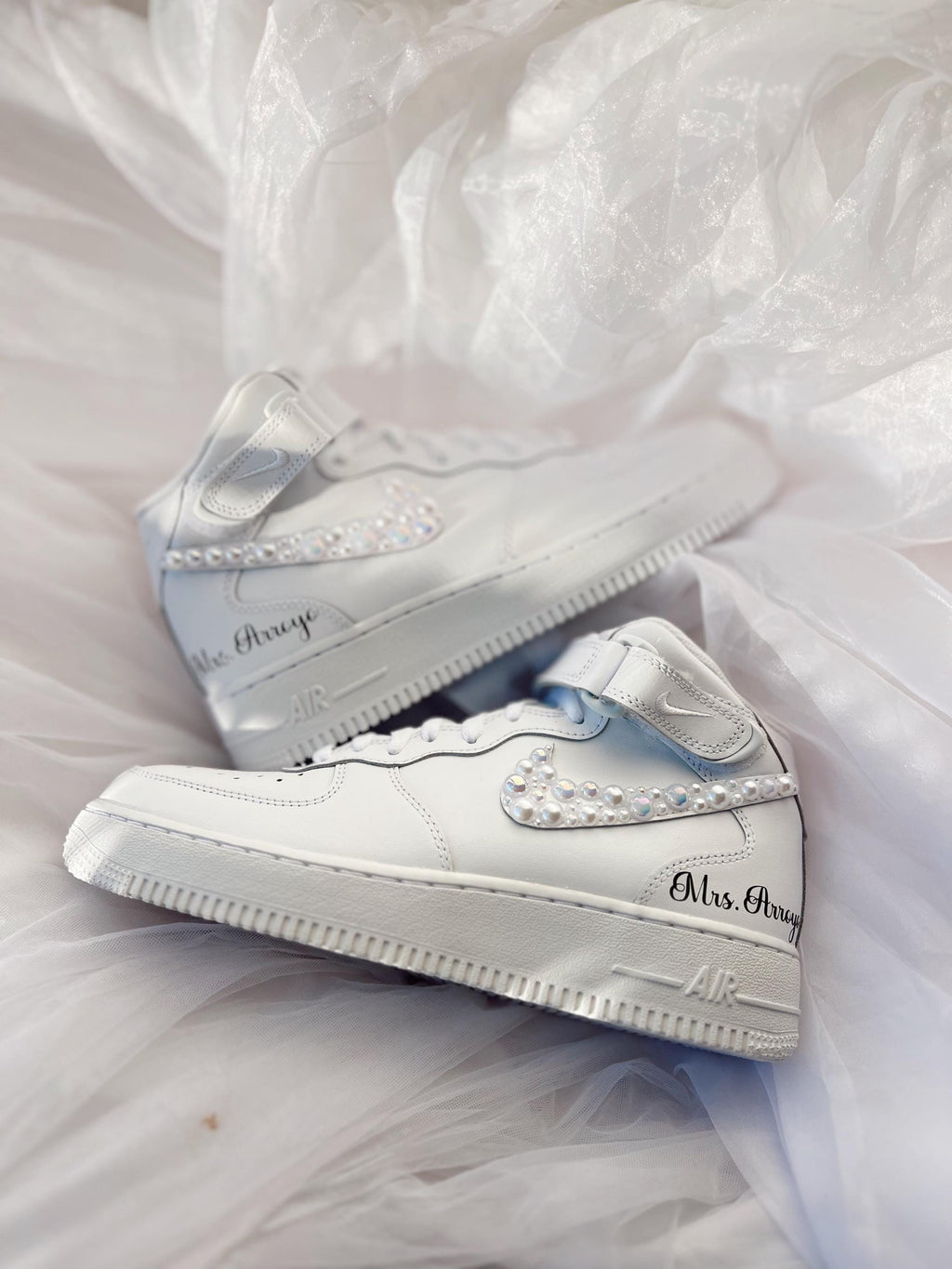 Close-up of hand-applied pearls on white wedding sneakers