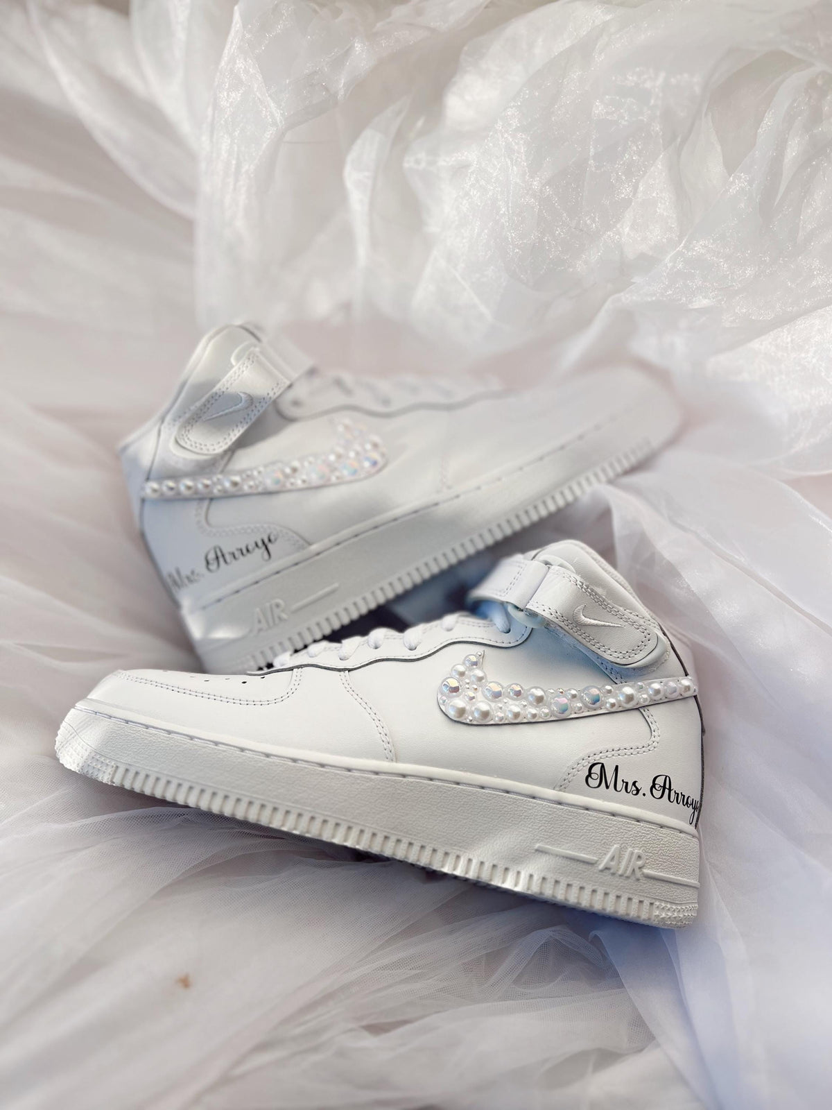 Close-up of hand-applied pearls on white wedding sneakers