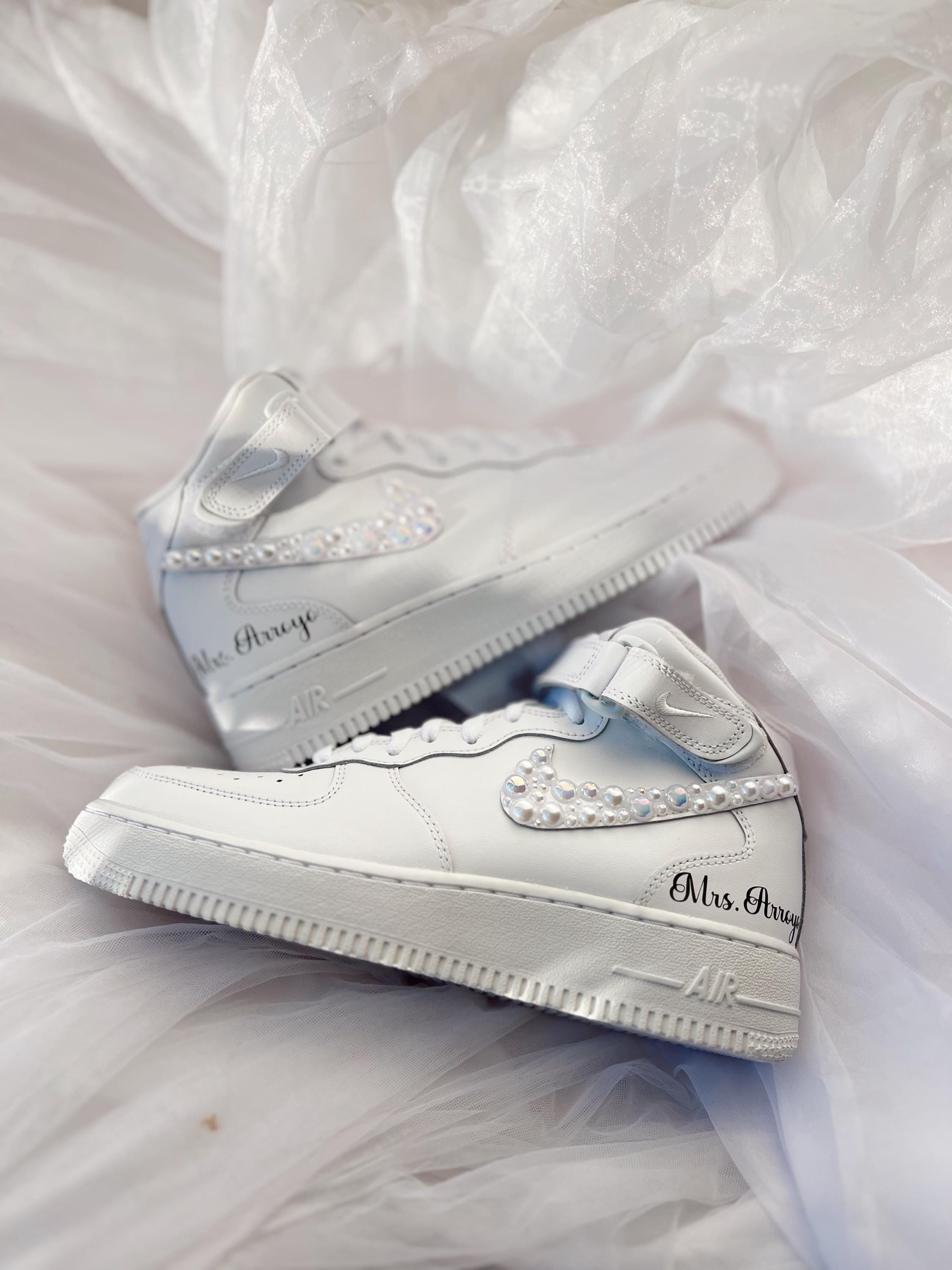 Close-up of hand-applied pearls on white wedding sneakers
