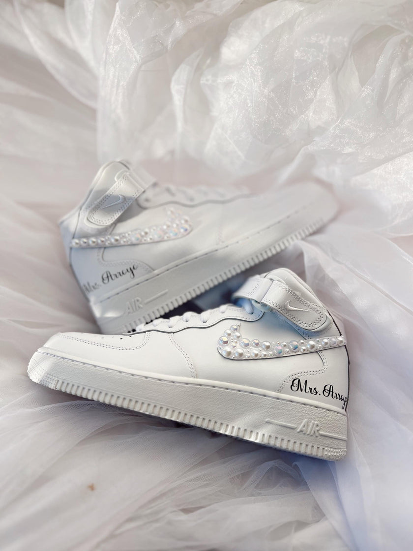 Close-up of hand-applied pearls on white wedding sneakers