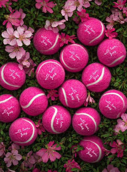 Personalized tennis balls designed as unique wedding favors for guests