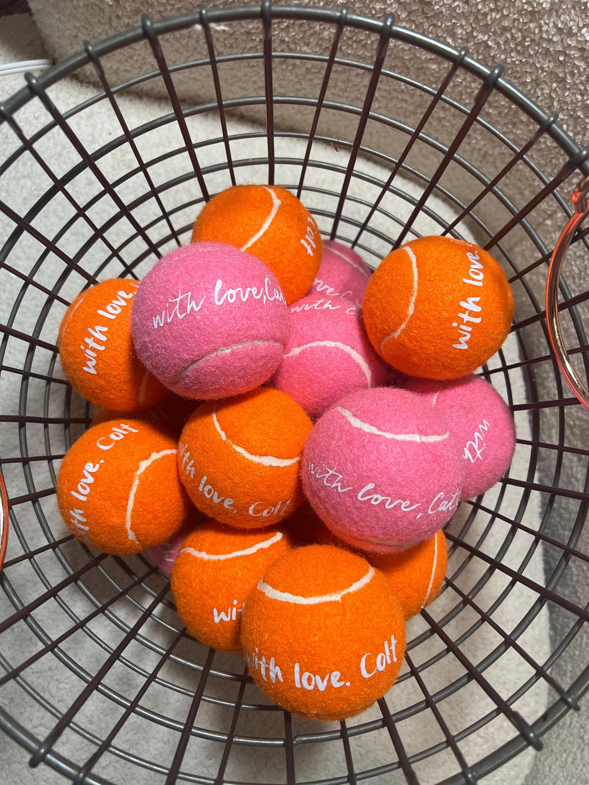 Custom tennis balls photographed on a tennis court as wedding favors