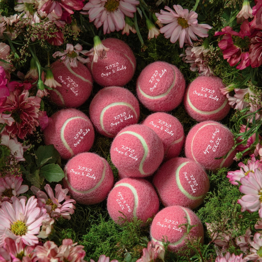Custom tennis balls displayed on a wedding favor table setup