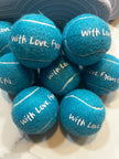 Custom tennis ball placed at guest table setting as wedding favor
