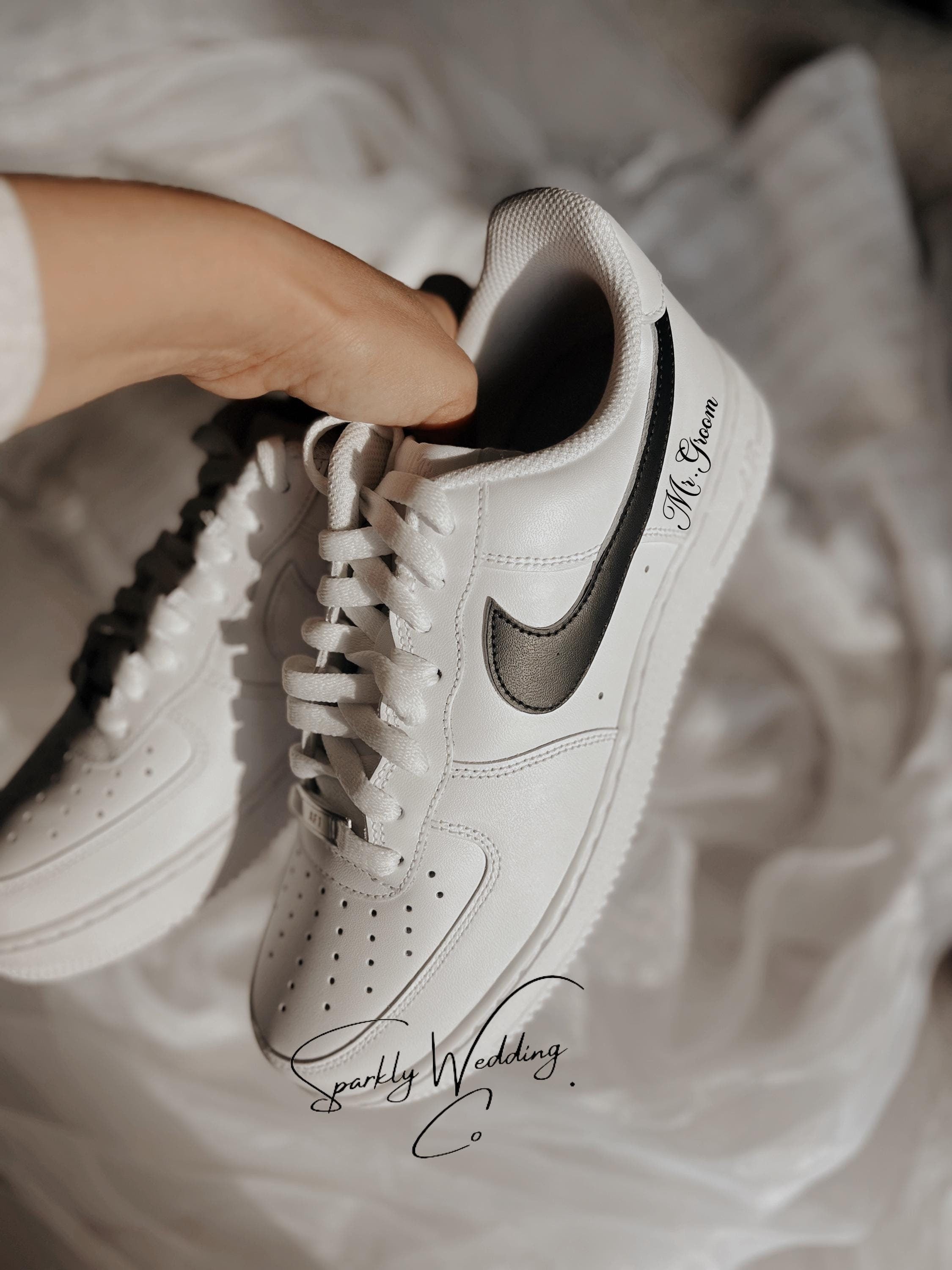 Custom black and white Nike Air Force 1 groom wedding sneakers with hand-painted outer swooshes, personalized with wedding name and date